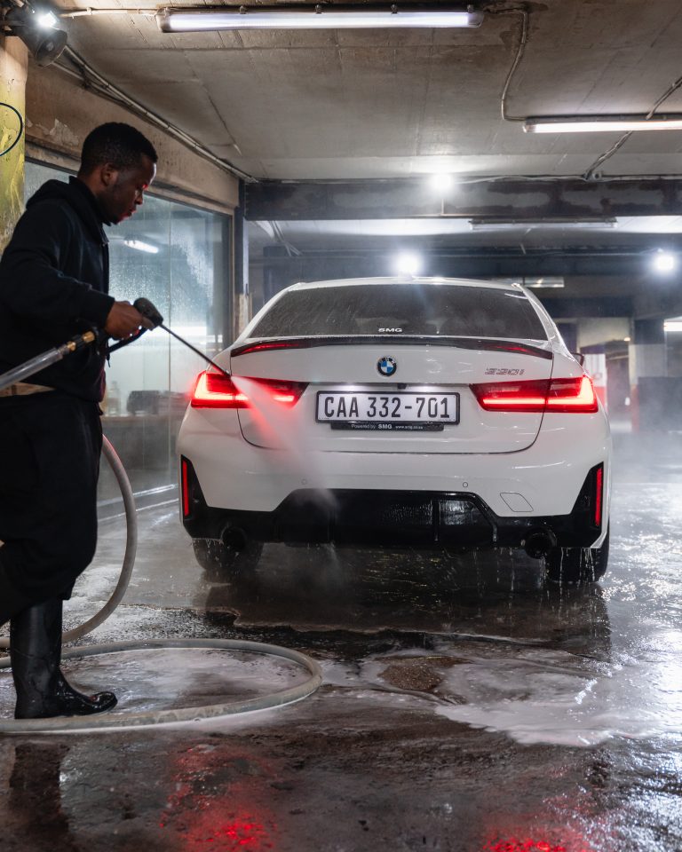 A Thunder Brothers technician rinsing a car down after a hand wash