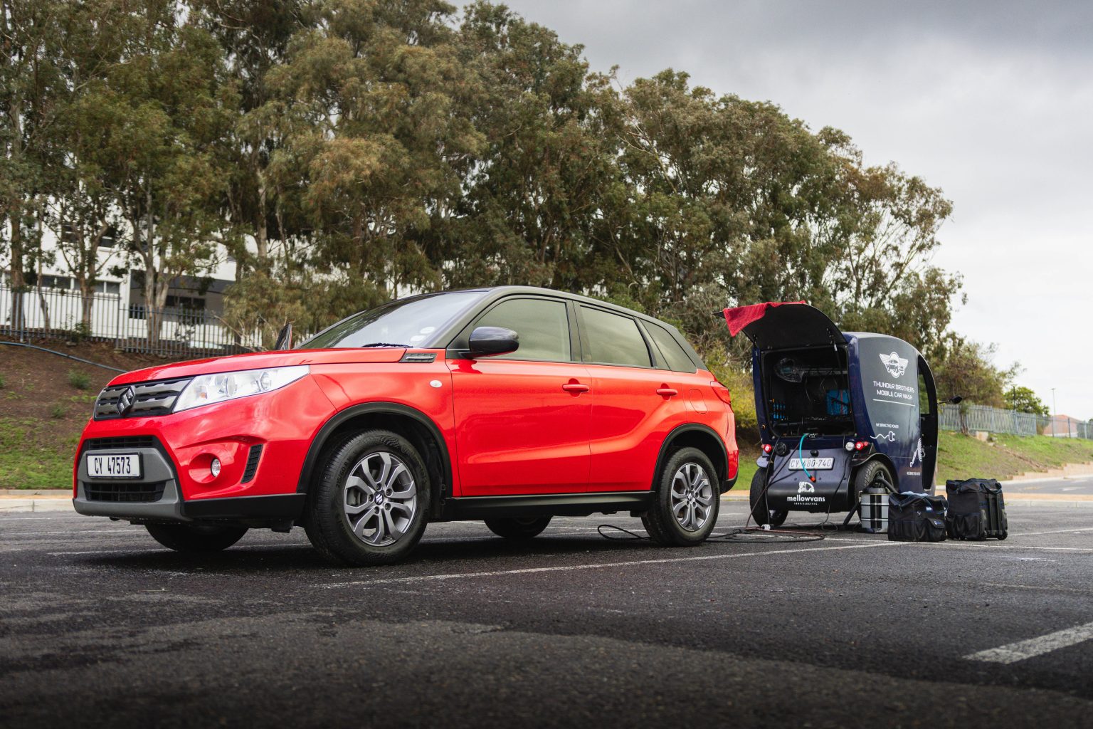 Thunder Brothers mobile car wash unit set up beside a car in an open parking bay with its cleaning kit ready